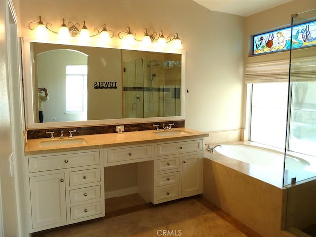 bathroom with a healthy amount of sunlight, tile patterned floors, a sink, and a shower stall