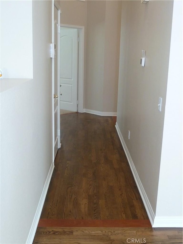 hallway with baseboards and wood finished floors