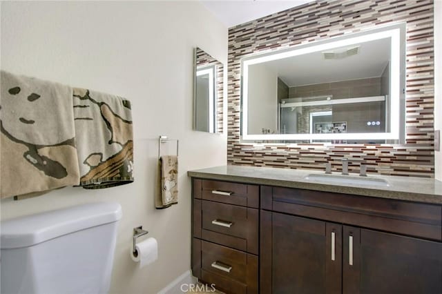 full bathroom featuring decorative backsplash, toilet, a shower stall, and vanity