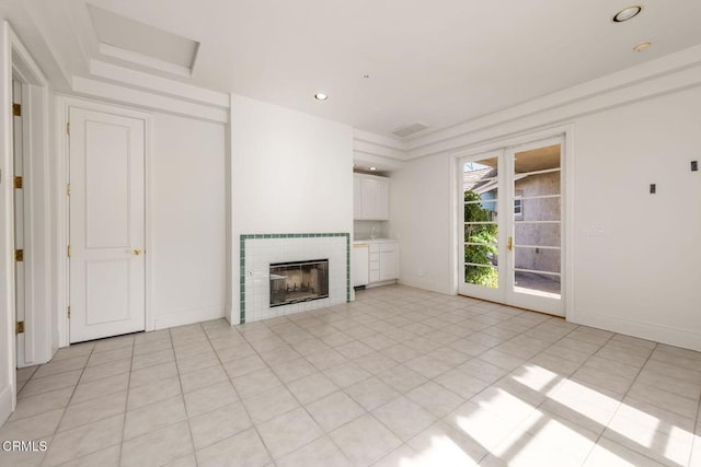 unfurnished living room featuring recessed lighting, light tile patterned flooring, a tiled fireplace, and baseboards