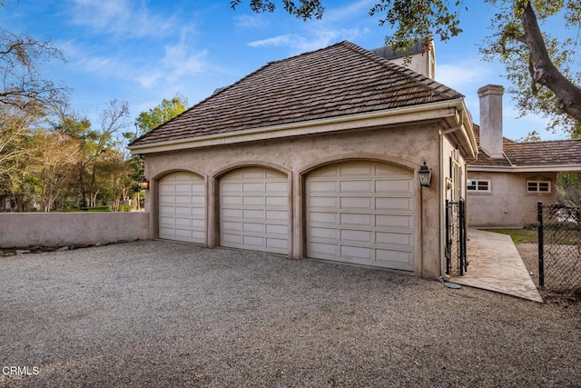 garage with driveway and fence