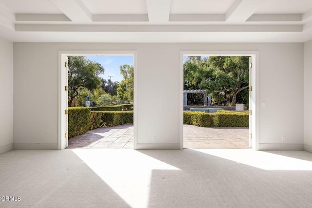 doorway with a healthy amount of sunlight, carpet, and coffered ceiling