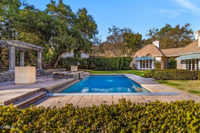 view of swimming pool featuring a patio area, a pool with connected hot tub, and a pergola