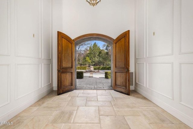 entrance foyer featuring stone tile floors and a decorative wall