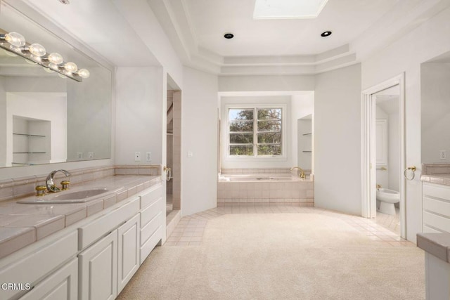 bathroom with a skylight, vanity, a bath, tile patterned floors, and a bidet