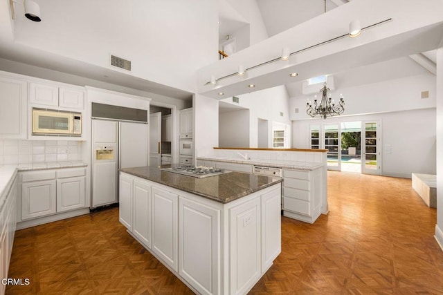 508 W Eucalyptus St, Ojai, CA 93023 - kitchen featuring white appliances, a kitchen island, high vaulted ceiling, a chandelier, and white cabinets