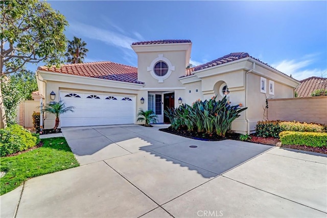 mediterranean / spanish-style house featuring a garage, stucco siding, concrete driveway, and a tiled roof