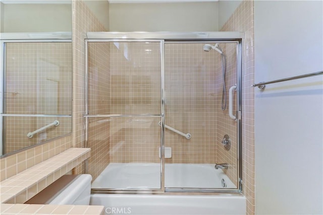 full bathroom featuring toilet and bath / shower combo with glass door