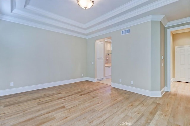 spare room featuring ornamental molding, baseboards, visible vents, and light wood finished floors