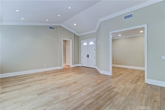 unfurnished room with vaulted ceiling, light wood-style flooring, visible vents, and crown molding