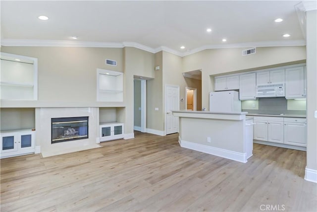 kitchen featuring open floor plan, white appliances, ornamental molding, and visible vents