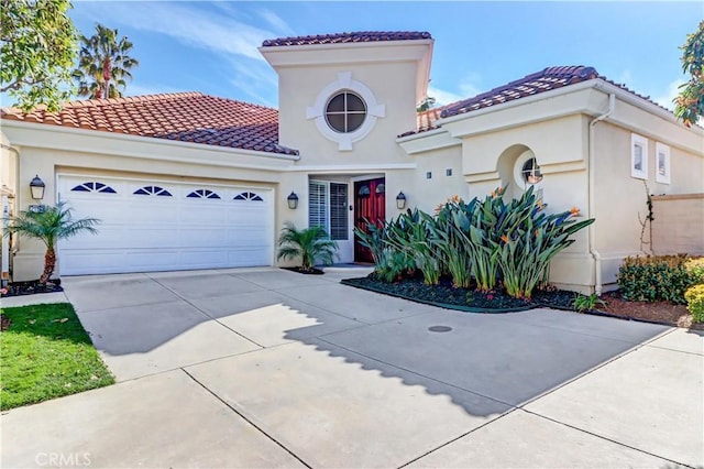 mediterranean / spanish-style house with an attached garage, driveway, a tile roof, and stucco siding