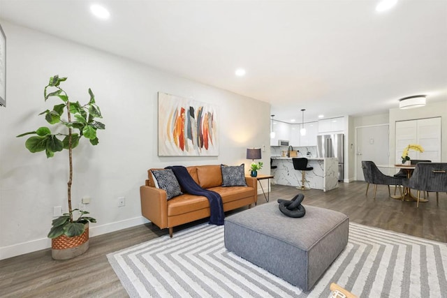 living area with recessed lighting, wood finished floors, and baseboards