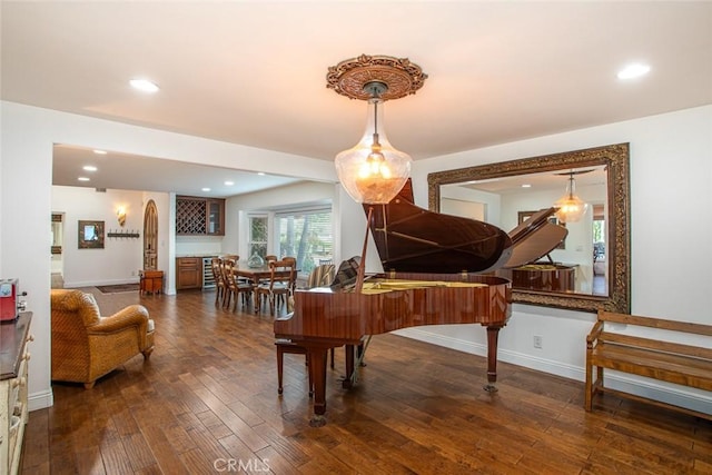 sitting room featuring baseboards, dark wood finished floors, and recessed lighting