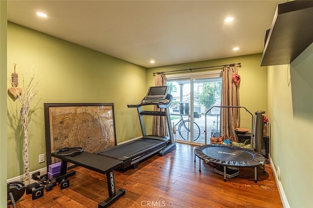 exercise area featuring recessed lighting, baseboards, and wood finished floors