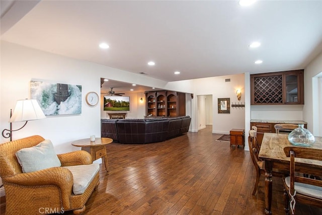 living room featuring a fireplace, dark wood-type flooring, and recessed lighting