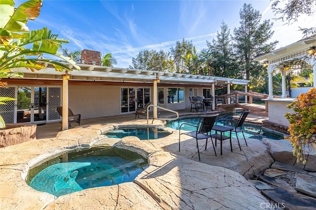 pool with a patio area and an in ground hot tub