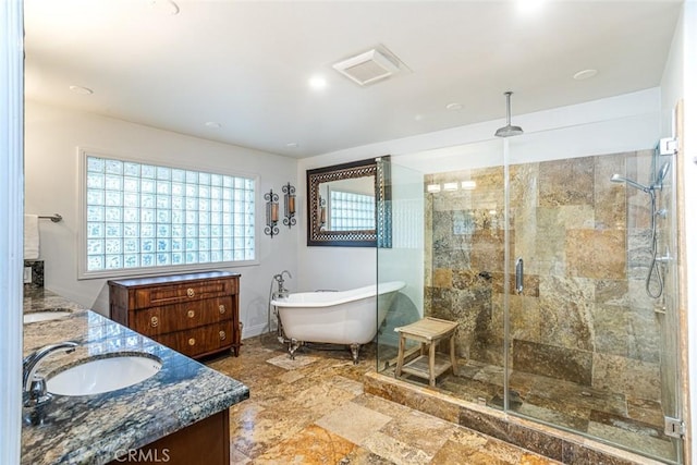 full bath featuring a stall shower, a soaking tub, a sink, and double vanity