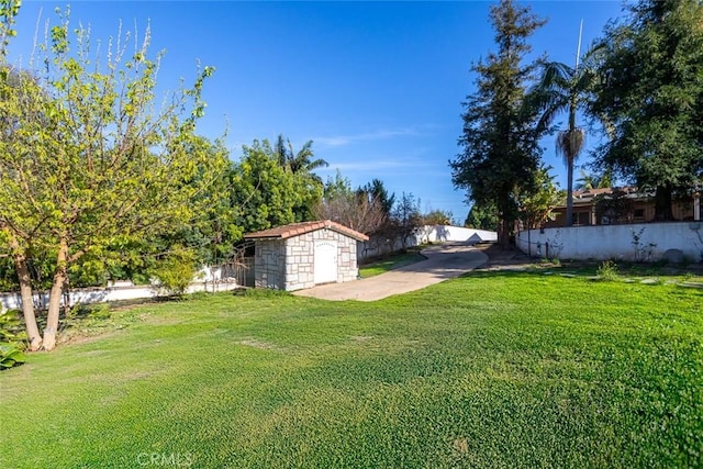 view of yard featuring a storage shed, an outdoor structure, and a fenced backyard