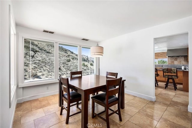 dining space featuring plenty of natural light, visible vents, and baseboards