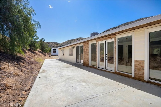 rear view of property featuring a patio area and a mountain view