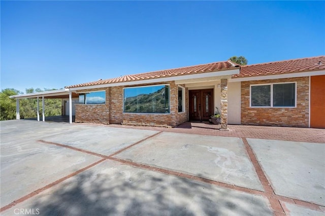 view of front of home featuring stone siding and a tile roof