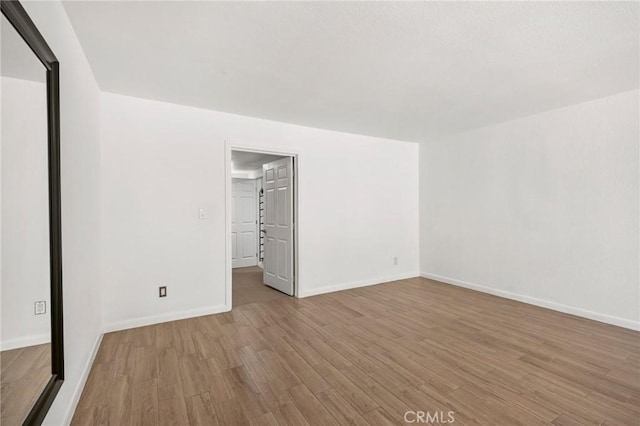 unfurnished room with wood finished floors and baseboards