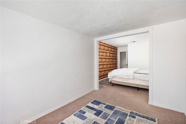 bedroom with visible vents, baseboards, a textured ceiling, and carpet flooring