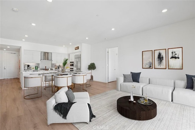 living area with light wood-style floors and recessed lighting