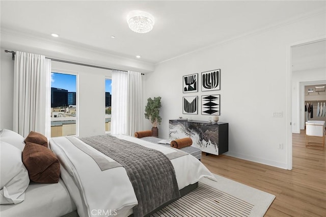 bedroom with ornamental molding, recessed lighting, baseboards, and wood finished floors