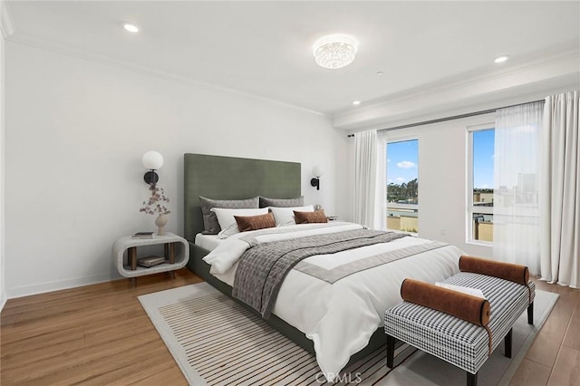 bedroom featuring baseboards, ornamental molding, and light wood-style floors