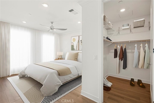 bedroom with recessed lighting, wood finished floors, visible vents, and baseboards