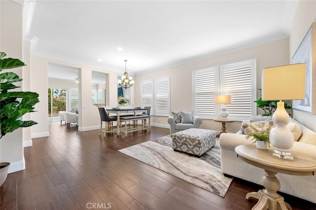 living area with dark wood-style flooring, crown molding, recessed lighting, a chandelier, and baseboards