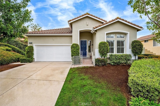 mediterranean / spanish-style house featuring a tile roof, driveway, an attached garage, and stucco siding