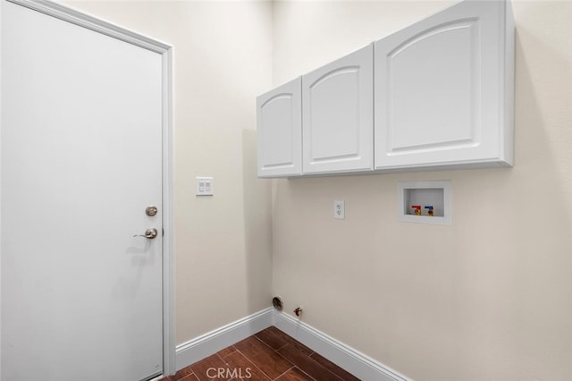 clothes washing area featuring gas dryer hookup, washer hookup, baseboards, cabinet space, and dark wood-style floors