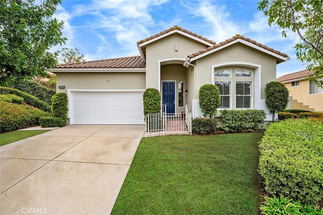 mediterranean / spanish-style home featuring an attached garage, driveway, a front lawn, and stucco siding