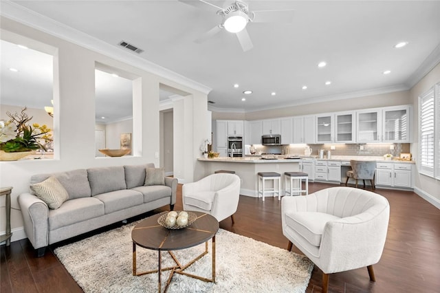 living room featuring dark wood-style floors, visible vents, crown molding, and recessed lighting