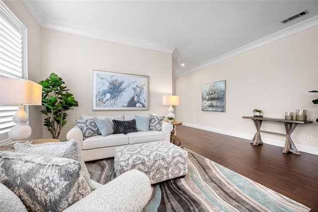 living room with baseboards, wood finished floors, visible vents, and crown molding