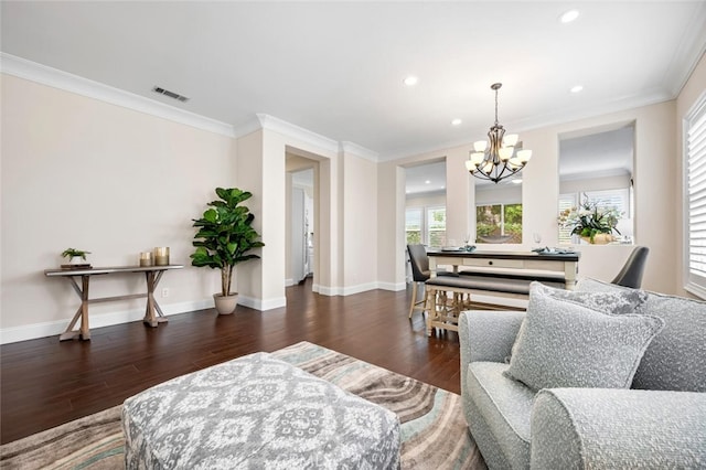 living room featuring baseboards, visible vents, wood finished floors, and ornamental molding