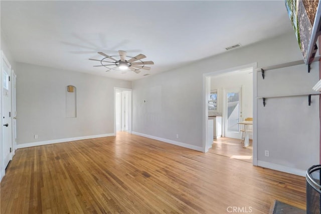 unfurnished living room with light wood-type flooring, ceiling fan, visible vents, and baseboards