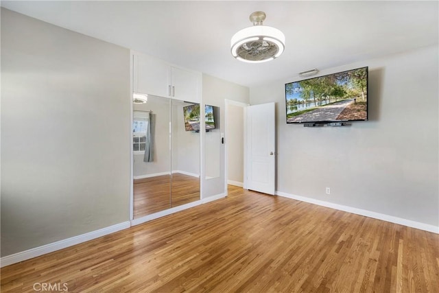 unfurnished bedroom with light wood finished floors and baseboards