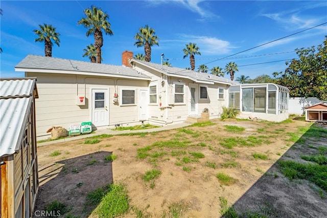 back of house featuring entry steps, crawl space, fence, and a sunroom