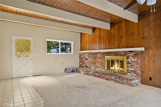 27008 Everest Rd, Lake Arrowhead, CA 92352 - unfurnished living room with wooden ceiling with exposed beams, a ceiling fan, wood walls, a fireplace, and carpet flooring