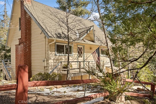 view of front of property with a shingled roof and a chimney