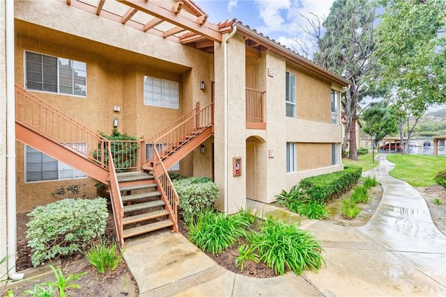 exterior space featuring stairs and stucco siding