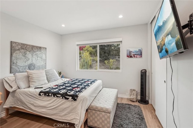 bedroom featuring baseboards, light wood-style flooring, and recessed lighting