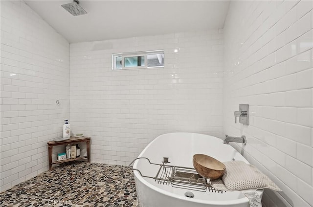 full bath featuring a soaking tub and tile walls