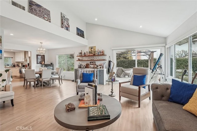 living room with high vaulted ceiling, light wood-style flooring, a chandelier, and recessed lighting