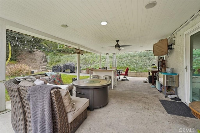 view of patio with a grill, outdoor dry bar, and a ceiling fan