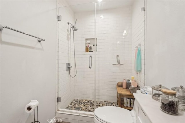 bathroom featuring a stall shower and toilet